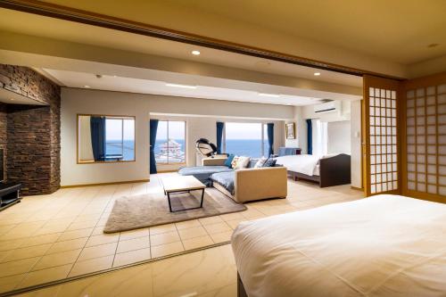 um quarto com uma cama e uma sala de estar em Mujuan em Atami