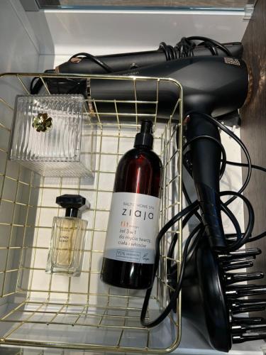 a shelf with a hair dryer and other items at Mazurskie Niebo Apartament 1 in Gołdap