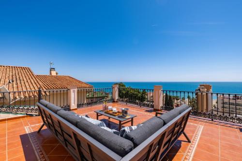 eine Terrasse mit einem Sofa und Meerblick in der Unterkunft Villa María Teresa in Málaga