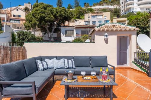 ein blaues Sofa auf einer Terrasse mit einem Tisch in der Unterkunft Villa María Teresa in Málaga