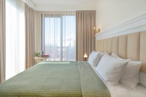 a bedroom with a large bed with a large window at Iris Hotel in Tbilisi City