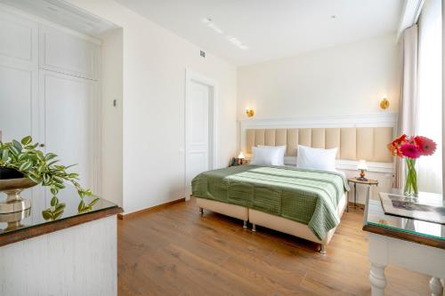 a bedroom with a bed with a green blanket at Iris Hotel in Tbilisi City