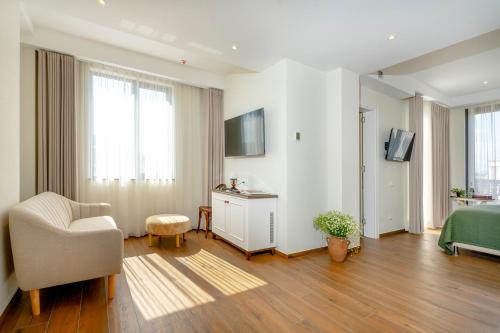 a room with a bed and a chair and a television at Iris Hotel in Tbilisi City