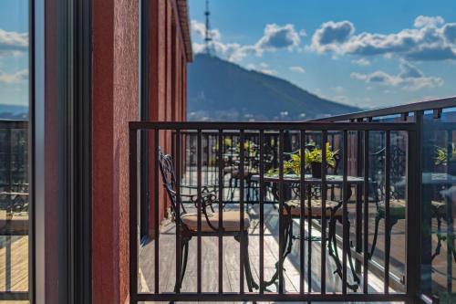 a table and chairs on a balcony with a view at Iris Hotel in Tbilisi City