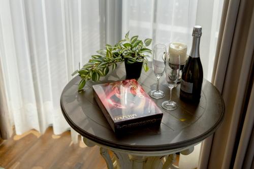 a table with a bottle of wine and wine glasses at Iris Hotel in Tbilisi City