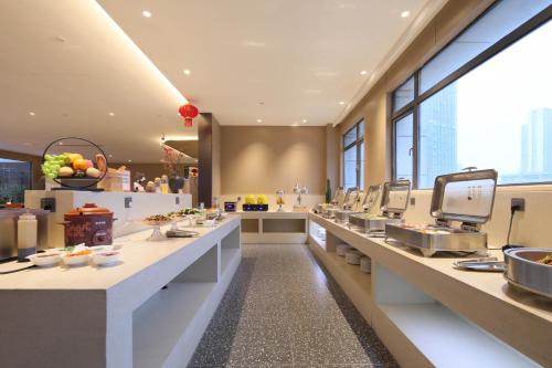 a restaurant with a buffet line with food at Ramada by Wyndham Wuhan Wangjiawan in Wuhan