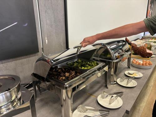 a person is preparing food in a kitchen at Apartamenty Rondo in Świnoujście