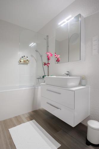a white bathroom with a sink and a toilet at Wave Luxury Apartment in Siófok
