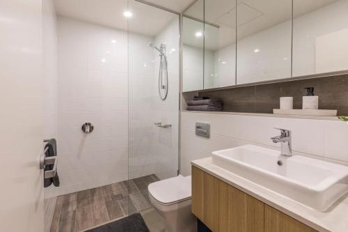 a bathroom with a sink and a toilet and a shower at Air Conditioned One Bedroom with Pool Close To CBD in Sydney