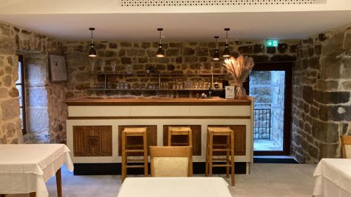 un bar en un restaurante con una pared de piedra en Aux Vieux Arceaux, en Mercuer