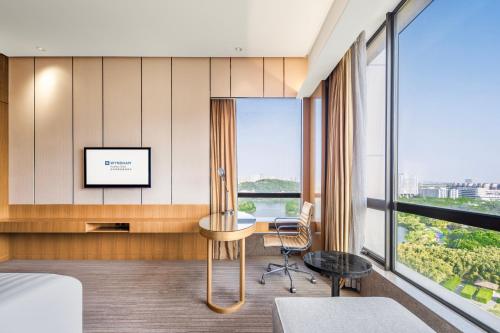 a hotel room with a desk and a window at Wyndam Xuzhou East in Xuzhou