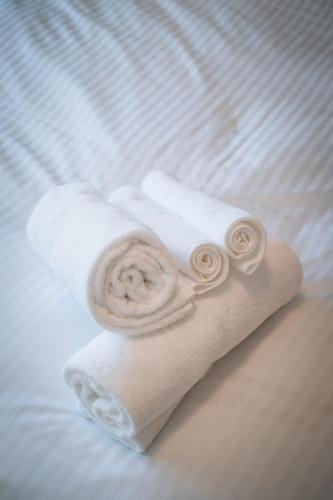 a stack of white towels on a bed at かものや洞爺ファーマーズハウス Kamonoya Toya Farmer's House in Tōya