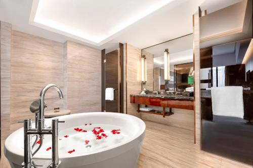 a bathroom with a tub with red flowers on it at Wyndam Xuzhou East in Xuzhou