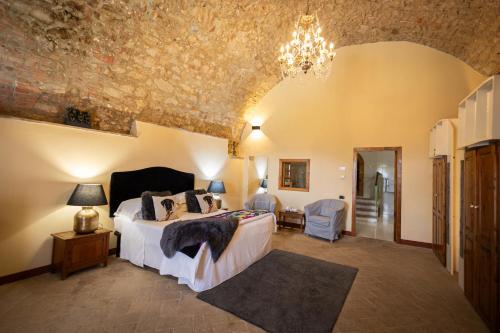 1 dormitorio con cama y lámpara de araña en LaChiusa Tuscany, en Montefollonico
