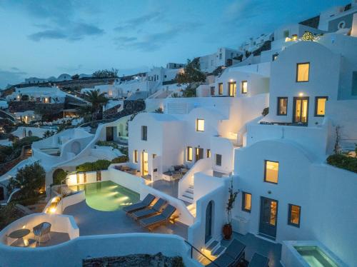 an aerial view of a white building with a swimming pool at IKIES Santorini in Oia