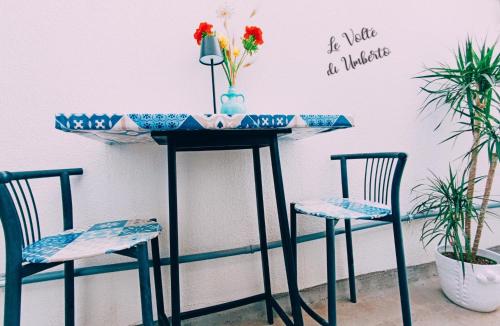 a table with two chairs and a vase with flowers on it at Le volte di Umberto in Sogliano Cavour