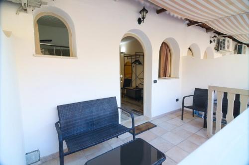 a room with a bench and a table and chairs at Oldwell Hotel in Santa Domenica