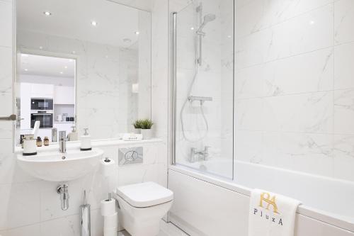 a white bathroom with a shower and a toilet and a sink at Pluxa Moonstone Metropolis Luxury Getaway in Birmingham City Centre in Birmingham