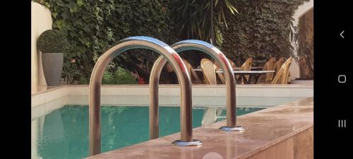 deux robinets métalliques sont à côté d'une piscine dans l'établissement gite la petite vigneronne, à Montagnac