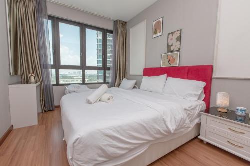 1 dormitorio con 1 cama blanca grande y cabecero rojo en I Soho at I City by Bai Yi # 0933a, en Shah Alam