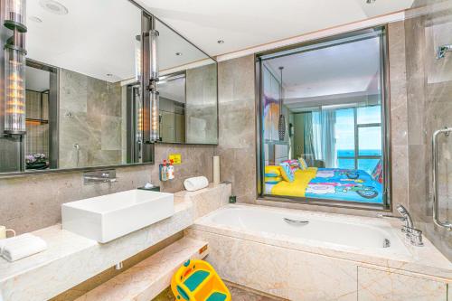 a bathroom with a tub and a sink at Crowne Plaza Beihai Silver Beach by IHG in Beihai