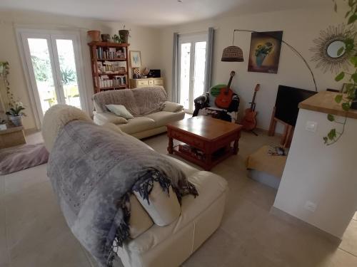 un salon avec un canapé et une table dans l'établissement Le bonheur en Provence, à Trets