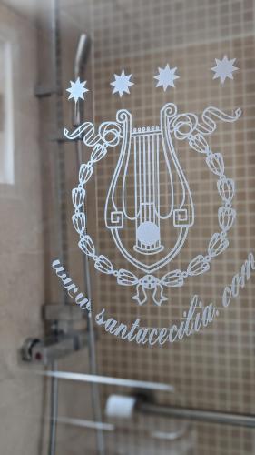 a reflection of a sign with a guitar on a shower curtain at Hotel Santa Cecilia in Ciudad Real