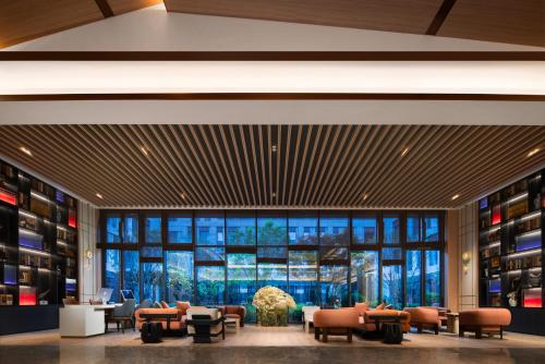 a lobby with couches and chairs and a large window at Holiday Inn Express Beijing Zhongguancun Tech Park by IHG l Next to The Old Summer Palace & Beijing Sport University l Taxi 10 Minutes to Summer Palace & Peking University & Tsinghua University in Beijing