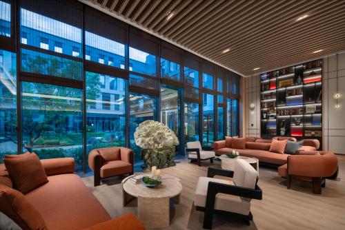 a lobby with couches and tables and windows at Holiday Inn Express Beijing Zhongguancun Tech Park by IHG l Next to The Old Summer Palace & Beijing Sport University l Taxi 10 Minutes to Summer Palace & Peking University & Tsinghua University in Beijing