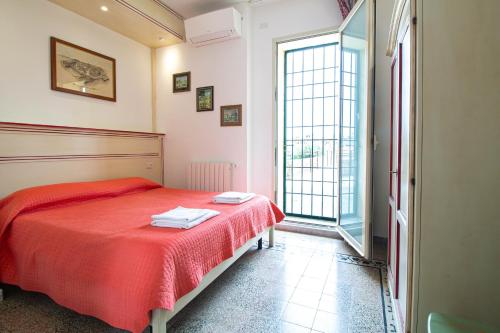 a bedroom with a red bed and a large window at B&B Le Mura in Grosseto