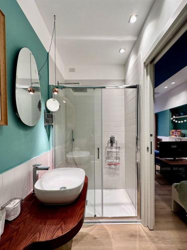 a bathroom with a glass shower and a white sink at La Nica in Palermo