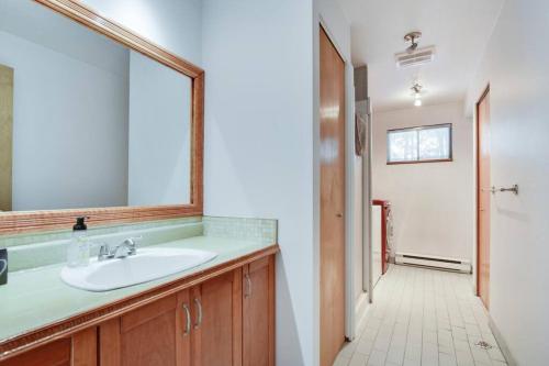 a bathroom with a sink and a mirror at Cozy home with hot tub near airport in Quebec City