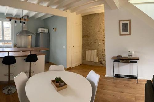 une cuisine et une salle à manger avec une table et des chaises blanches dans l'établissement Tiny Paradise - 2 Bedrooms Apartment, à Montigny-sur-Loing