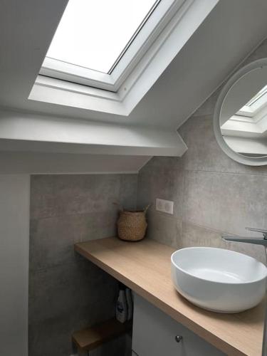 une salle de bain avec un lavabo blanc et une lucarne dans l'établissement Tiny Paradise - 2 Bedrooms Apartment, à Montigny-sur-Loing