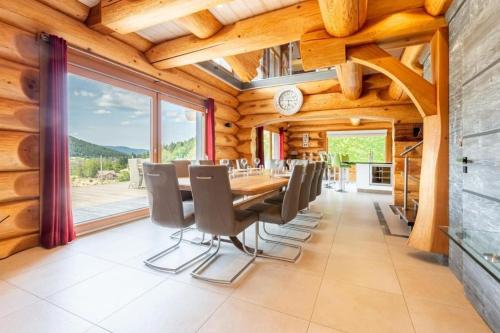 une salle à manger avec une longue table et des chaises dans l'établissement Merveille architectural en rondins chalet Whistler, à Xonrupt-Longemer