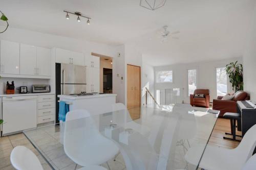 a kitchen and living room with a glass table and chairs at Cozy home with hot tub near airport in Quebec City