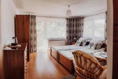 a bedroom with a bed and a table and chairs at Pokoje Marzena in Ochotnica Górna
