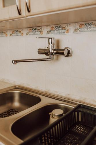 a kitchen sink with a dish drying rack next to it at Pokoje Marzena in Ochotnica Górna