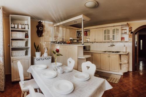 a kitchen with a table with white plates on it at Pokoje Marzena in Ochotnica Górna