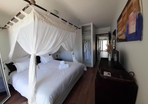 a bedroom with a white bed with a canopy at Cap Saint Martin Marina in Cap d'Agde