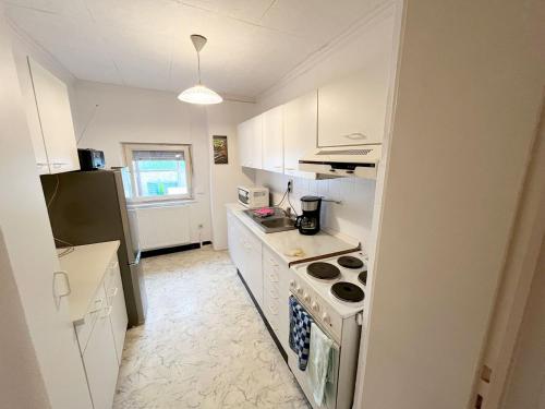 a kitchen with white cabinets and a stove top oven at 5 Room Apartment in Zülpich in Zülpich