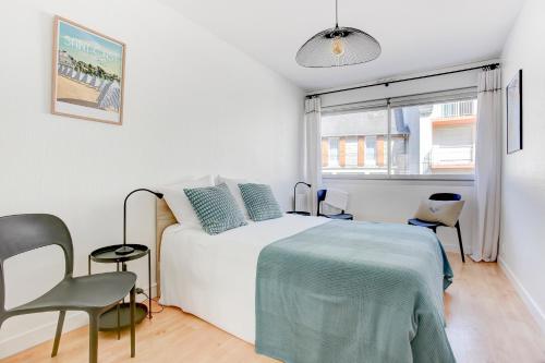 Un dormitorio blanco con una cama y una ventana. en L'Emérillon - Appt à 200m de la plage, en Saint-Cast-le-Guildo