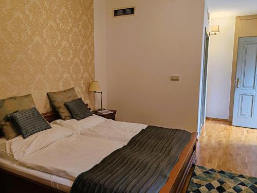 a bedroom with a large bed in a room at Városi Vendégház Szentendre in Szentendre