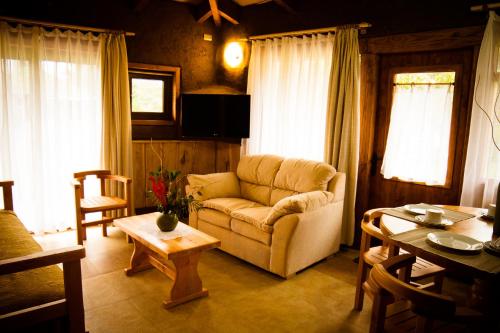 a living room with a couch and a table at Complejo Cabañas Quilamalen in Villarrica