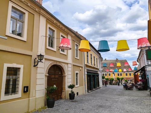 a street with colorful lights hanging from buildings at Városi Vendégház Szentendre in Szentendre