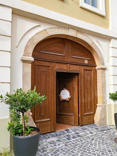 a large wooden door with an archway in a building at Városi Vendégház Szentendre in Szentendre