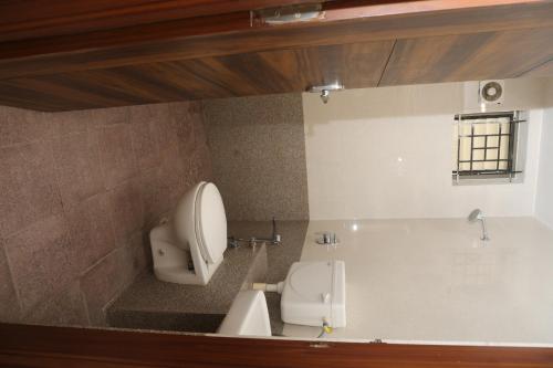 a bathroom with a tub with a toilet and a sink at virat inn in Bangalore