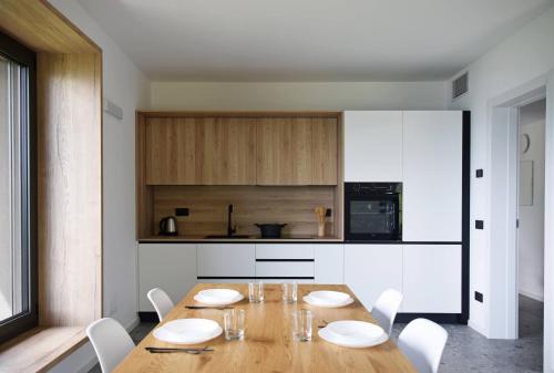 a kitchen with a wooden table and white chairs at La casa di Cesare in Rogno