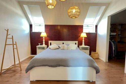 een slaapkamer met een wit bed en 2 lampen bij Villa d'architecte avec vue imprenable in Péruwelz