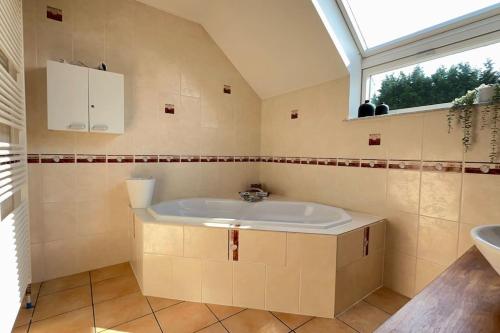 een badkamer met een bad, een raam en een wastafel bij Villa d'architecte avec vue imprenable in Péruwelz